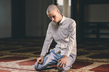 Fototapeta premium Muslim boy praying in a Mosque