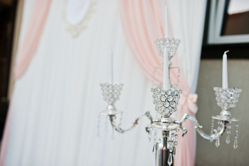 Silver vintage chandelier against wedding arch at ceremony.