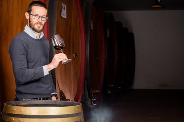 Sommelier tasting wine in the cellar