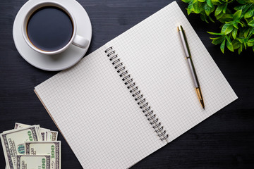 Coffee cup and notebook on wooden table background
