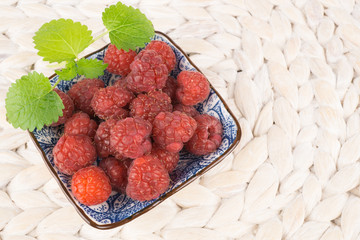 Kleine Schale mit frischen Himbeeren, Zitronenmelisse als Dekoration