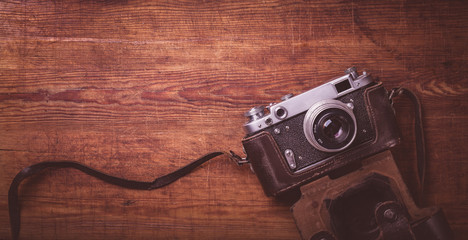Retro camera on wood table background vintage color tone