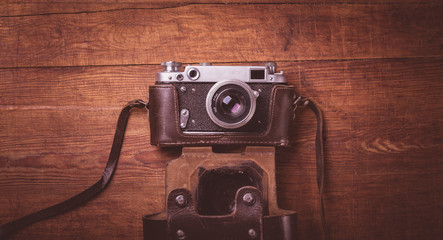 Retro camera on wood table background vintage color tone