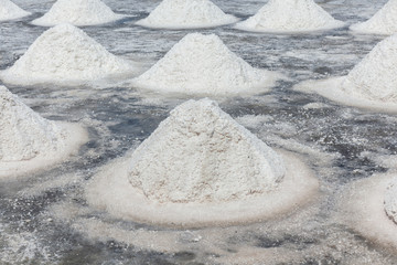 Piles of sea salt crystalline in field prepare for harvesting, salt industry in Thailand.