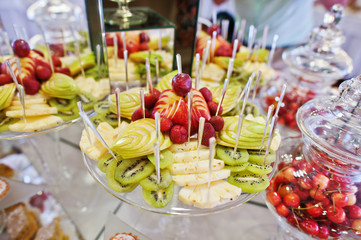 Fototapeta na wymiar Wedding reception table with different fruits, cakes and sweets.