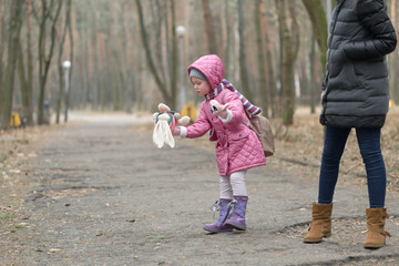 Fototapeta premium Little girl dropped the doll on a walk