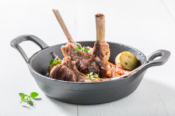Delicious roasted lamb ribs with vegetables on the white table © shaiith