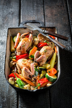 Homemade quails with vegetables and spices in casserole