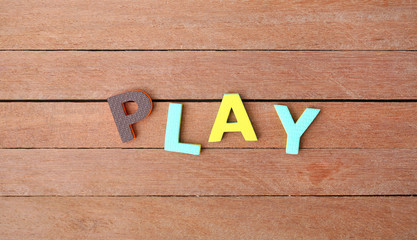 Alphabet letters "PLAY" on wood plank. Education concept.