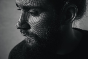 Young bearded man with shadows on face