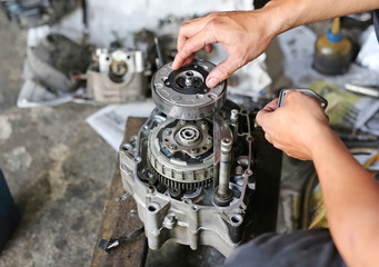 a pair of technician hand fixing the motorcycle