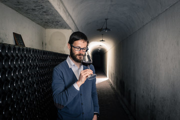 Sommelier tasting red wine in the cellar