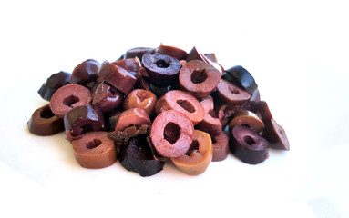 Heap of sliced olives on white