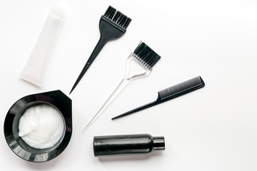 hair dye with brush on white table background top view