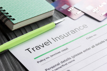 Traveling concept with insurance application on wooden table