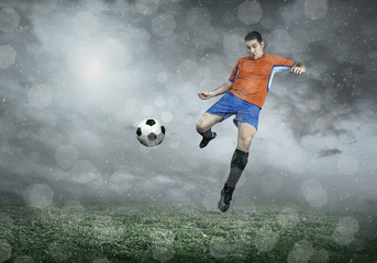 Naklejka premium Football player with ball in action under sky with clouds