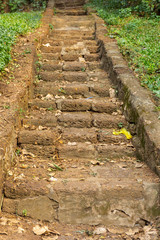 Old stone stair case going up hill with depth of field.