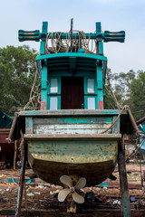 Obraz premium Old wooden fishing boat in a messy dry dock for repair.
