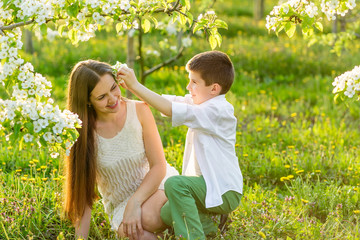 Naklejka premium Mama gently hugs her son in the rays of the setting sun