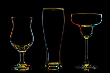 Silhouette of multicolor different glasses on black background