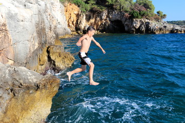 Junge springt ins Meer