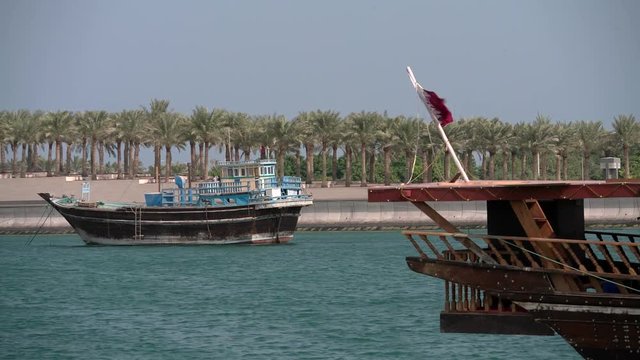 Traditional dhow sailing vessels docked beside the Corniche in Doha, Qatar.