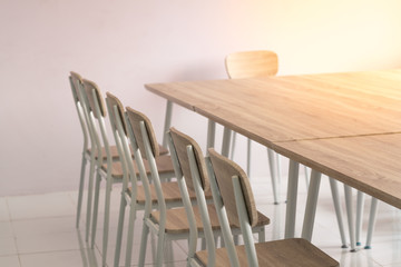 Empty rough wooden chairs and table in the conference room - warm tone effect.