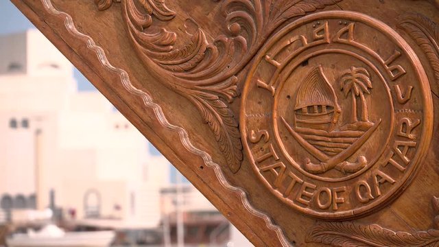 Wooden seal carved on traditional dhow sailing vessel docked beside the Corniche in Doha, Qatar.