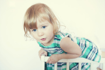 Fototapeta premium funny little girl is in the crib