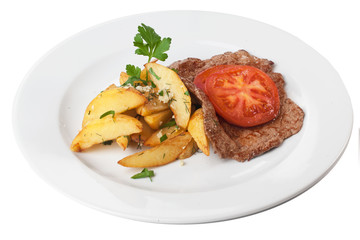 chop steak with French fries tomato and parsley on a plate isolated