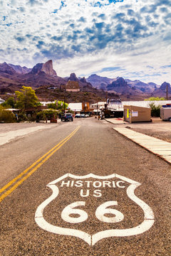 Historic US Route 66 with highway sign on asphalt and a panoramic view of Oatman, Arizona, United States. The picture was made during a motorcycle road trip through the south western states of USA.