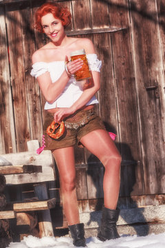Bayerische junge Frau mit Bier und Brezel