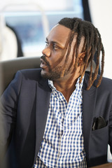 Profiled African American businessman with rasta hair sitting at his desk in office