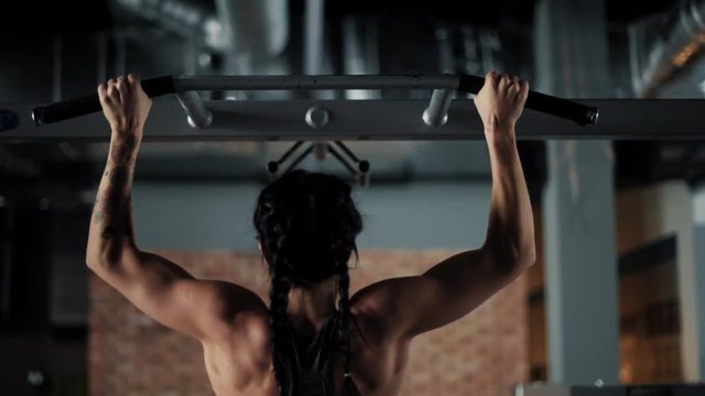 Woman using bar to do chin ups 