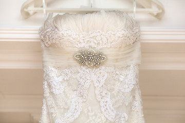 A close up of a wedding dress with a large silk bow