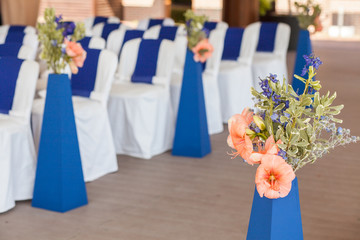 Beautifuly decorated with white and blue cloth and flowers chairs