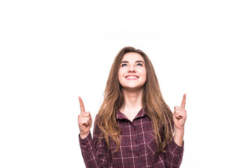 Portrait of a smiling girl pointing fingers up at copyspace isolated