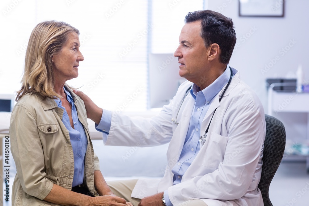 Wall mural Doctor consoling senior woman