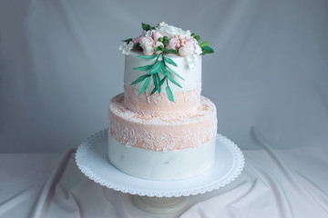 Spring two-tiered cake decorated with roses from mastic top