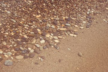 Fototapeta na wymiar Close up of a pebble beach with the sea.