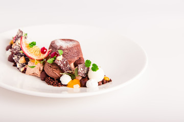 chocolate dessert with fruits on a white plate in a restaurant