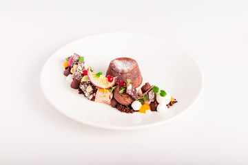 chocolate dessert with fruits on a white plate in a restaurant