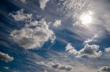 bright blue sky with clouds and sun 