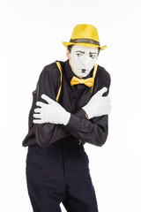 Portrait of a man, pantomime in confusion, showing that he is afraid. Isolated on white background.