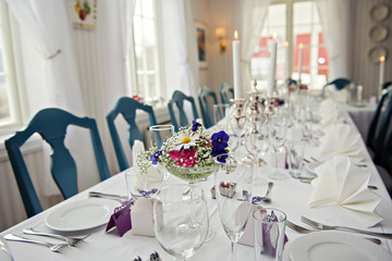 A very nicely decorated wedding table with plates and serviettes.