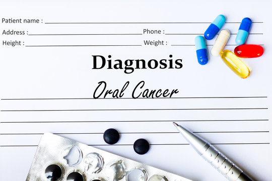 Oral Cancer - Diagnosis written on a piece of white paper with medication and Pills