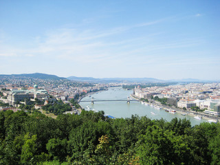 Fototapeta premium Beautiful view of Buda and Pest, eastern and western parts Budapest city, Hungary from up top Panorama with Danube river, the biggest river in Europe on sunny summer day with clear blue sky background