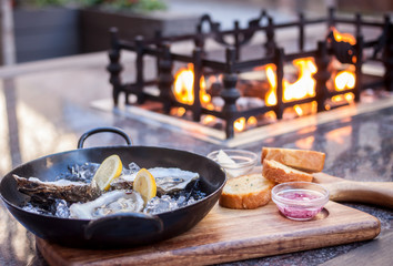 fresh opened oysters fireplace background