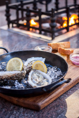 fresh opened oysters fireplace background