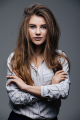 Portrait of beautiful caucasian woman standing on grey background.